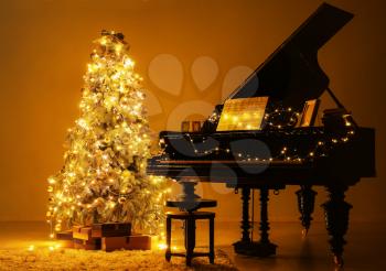 Grand piano in room decorated for Christmas at night�