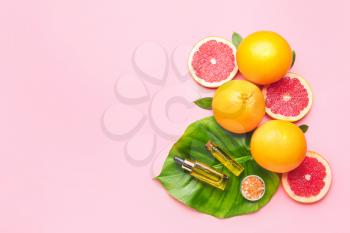Bottles of essential oil, grapefruits and sea salt on color background�