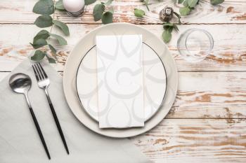 Beautiful table setting with empty menu on white wooden background�