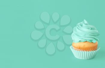 Tasty cupcake on color background�