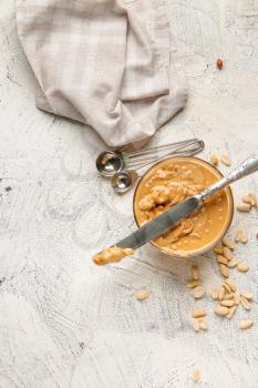Bowl with tasty peanut butter and knife on white background�