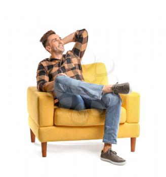 Handsome man sitting in armchair on white background�