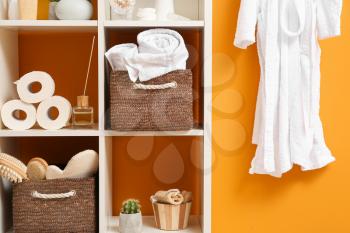 Body care cosmetics with accessories on rack in bathroom�