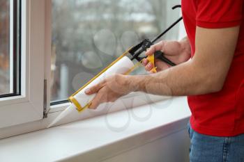 Young worker installing window in flat, closeup�