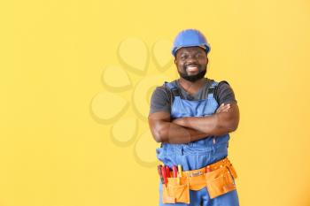 African-American electrician on color background�