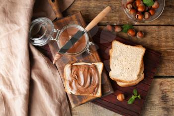Fresh bread with tasty chocolate paste on table�