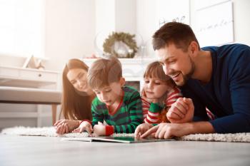 Happy family reading book at home�