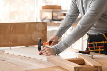 Handyman assembling furniture in workshop�