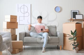 Asian man sitting on sofa after moving to new house�