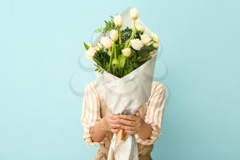 Female florist with beautiful bouquet on color background�