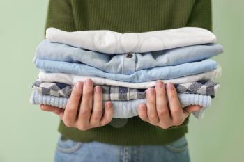 Young woman with clean clothes on color background, closeup�