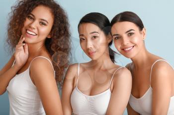Beautiful young women with healthy skin on color background�