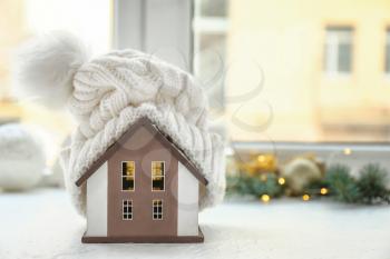 Model of house with hat on window sill. Winter concept�