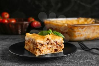 Plate with prepared lasagna on dark table�