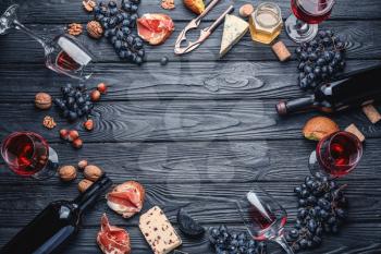 Frame made of delicious wine with snacks on dark wooden background�