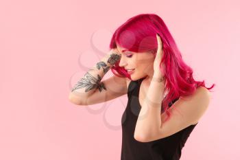 Beautiful young woman with unusual hair on color background�