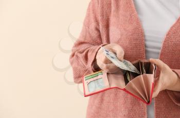 Senior woman with wallet on color background, closeup�