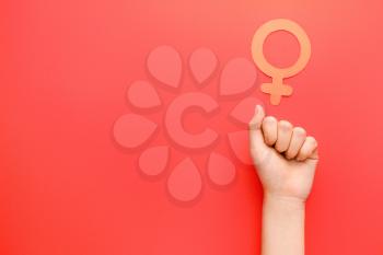Female hand with symbol of woman on color background. Concept of feminism�