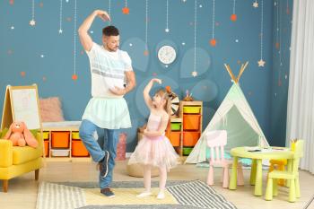 Father and his little daughter dancing at home�