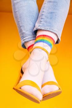 Legs of young woman in socks and sandals on color background�