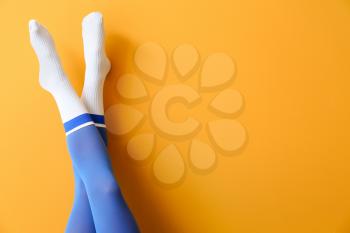 Legs of young woman in socks and tights on color background�