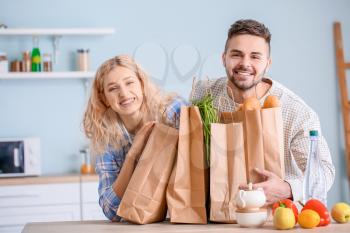 Couple unpacking fresh products from market in kitchen�