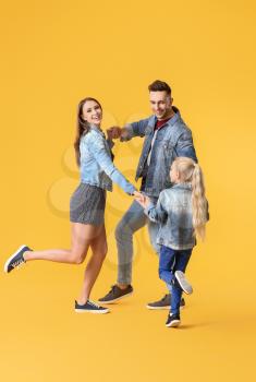 Happy family dancing against color background�