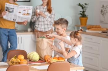 Family unpacking fresh products from market in kitchen�