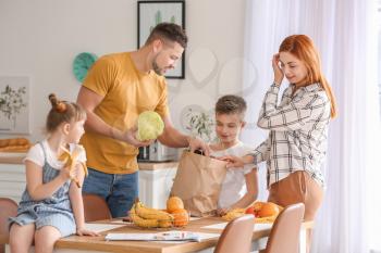 Family unpacking fresh products from market in kitchen�