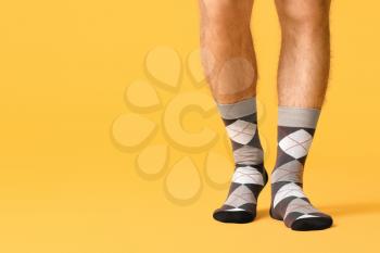 Male legs in socks on color background�
