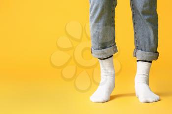 Male legs in socks and jeans on color background�