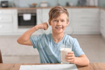 Little boy with milk in kitchen�