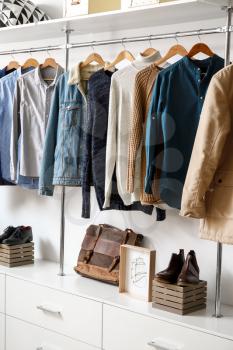 Modern wardrobe with stylish winter clothes and accessories�