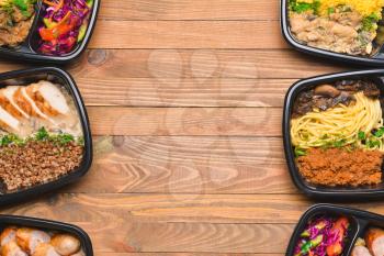 Containers with healthy food on wooden background�
