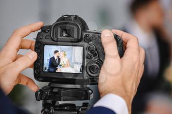 Photographer working with young wedding couple in studio, closeup�
