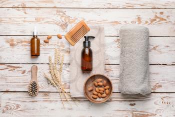 Composition with shampoo and natural ingredients on wooden background�