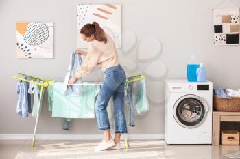 Young woman doing laundry at home�