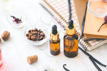 Bottles of perfume oil with ingredients on table�