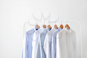 Rack with clothes on light background�