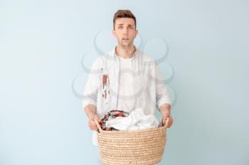 Troubled man with dirty clothes on color background�