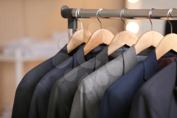 Hanger with different stylish male suits in store�
