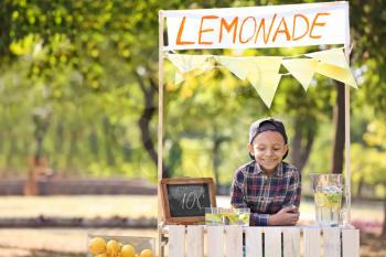 Little African-American boy at lemonade stand in park�