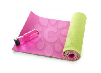 Yoga mat with bottle of water on white background�
