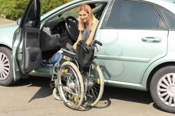 Handicapped woman getting out of her car�