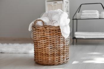 Laundry basket with dirty towels on floor�