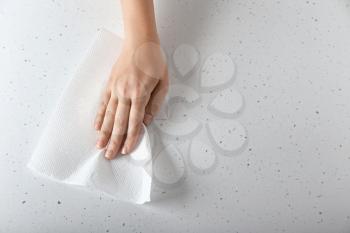 Woman wiping light table with paper towel�