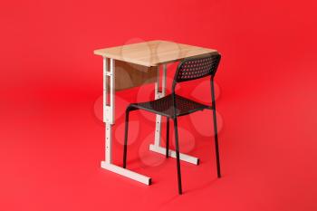 School desk with chair on color background�