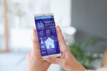 Woman using application of smart home automation�