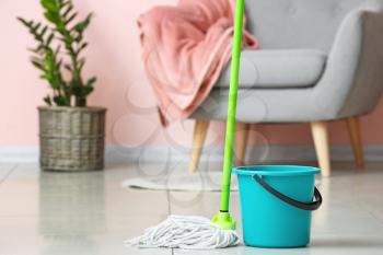Mop and bucket on floor in room�