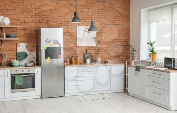 Stylish interior of modern kitchen with big refrigerator�